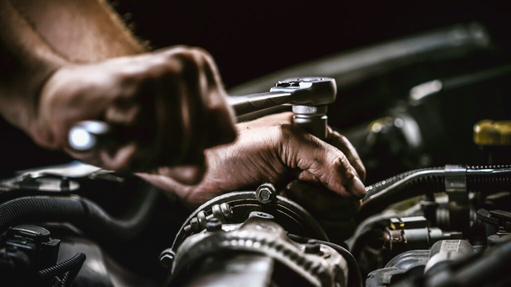 Automechaniker bei der Arbeit an einem Automotor in einer Autowerkstatt. Reparatur