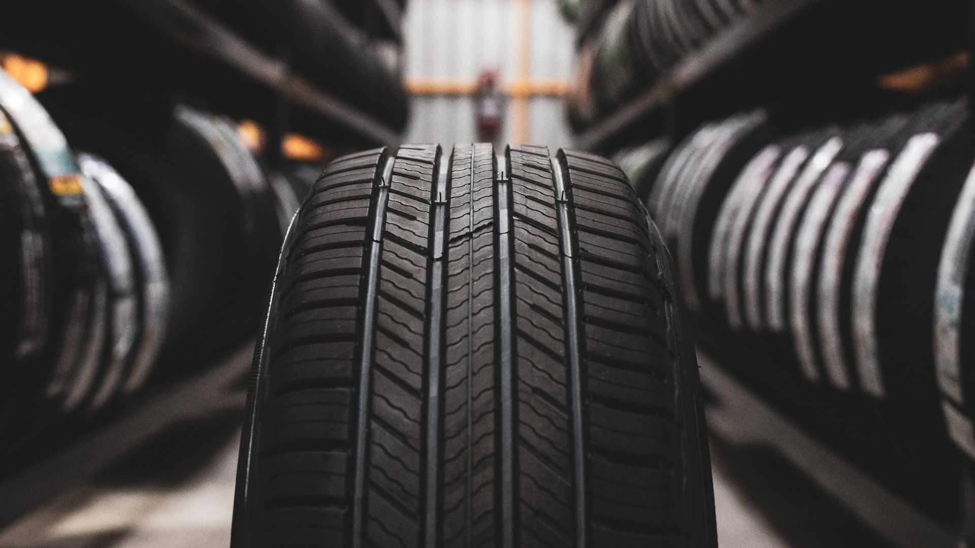 Ein neuer Reifen wird auf dem Reifenständer in der Autowerkstatt gelagert